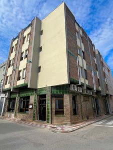 a large brick building on the corner of a street at Hostal Tarrés in Anglés