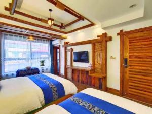 Habitación con 2 camas y TV. en Wuling Spring Inn, Yongding District, Zhangjiajie City, 