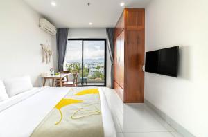 a hotel room with a bed and a television at LAM Apartment & Hotel Danang - Quiet Living in Modern Comfort in Danang