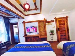 Un dormitorio con dos camas y un televisor de pantalla plana. en Wuling Spring Inn, Yongding District, Zhangjiajie City, 