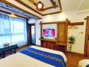 Un dormitorio con una cama y un televisor de pantalla plana. en Wuling Spring Inn, Yongding District, Zhangjiajie City, 