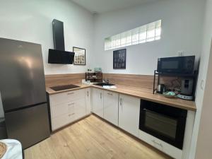 a kitchen with white cabinets and a wooden counter top at La Maison D'isaure 6 personnes Parthenay centre in Parthenay