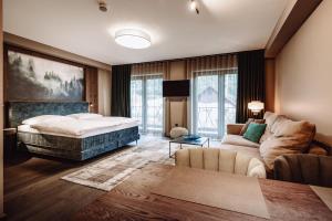 a bedroom with a bed and a living room with a couch at Dillhof Apartments in Eschau