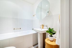 Un baño blanco con lavabo y espejo. en Welcome London Covent Garden Piazza, en Londres 22 fotos más