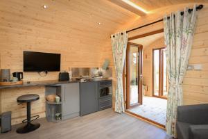 a log cabin with a kitchen and a television at Luxury Glamping Pod - Garthside Farm Holidays in Brampton