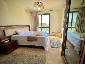 a hotel room with a bed and a window at Luxury Stylish Modern 2 Beds Hotel Apartment - East Town Compound - Sodic -New Cairo - Cairo - Egypt in Cairo +91 photos