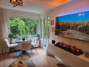 a living room with a fireplace and a large tv at Strandzauber und Kaminflair-Balkon, PP & King Bed in Glücksburg +13 photos