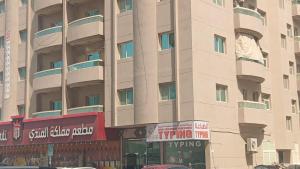 a large building with a sign in front of it at Friends Hotel Apartments in Ajman 