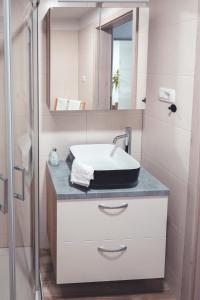 un baño con lavabo y espejo en Maribella Apartment, en Maribor 24 fotos más