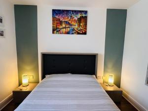 a bedroom with a large bed with two lamps at Grand Central Apartments in Derby