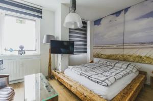 a bedroom with a bed and a tv and a window at Wismarer Heckflosse - ABC607 in Wismar