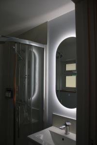 un bagno con lavandino, doccia e specchio di The Nestle - A Romantic Rural Retreat a Ilminster