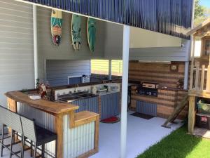 an outdoor kitchen with a sink and a table at Holiday house in Nelson Bay