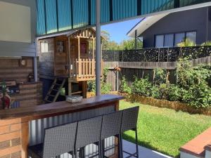 a backyard with a bar and a house at Holiday house in Nelson Bay