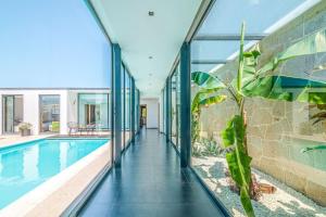 una casa con pareti in vetro e una piscina di Portugal Active Sunset Beach Lodge a Paço Altre 61 foto