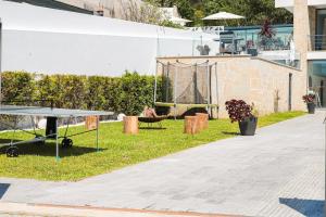 un tavolo da ping pong sull'erba accanto a un edificio di Portugal Active Sunset Beach Lodge a Paço