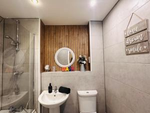 a bathroom with a sink and a toilet and a mirror at Grand Central Apartments in Derby +43 photos