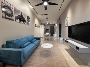a living room with a blue couch and a flat screen tv at ICC Suites Ipoh City Centre Walk C1212A in Ipoh