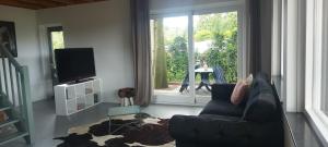 WijsterにあるVakantiehuis met prachtig uitzichtのソファと大きな窓のあるリビングルーム