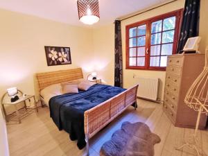 ein Schlafzimmer mit einem Bett, einer Kommode und einem Fenster in der Unterkunft Le Saint M, T3, wifi, parking, jardin, Saint Mamet in Saint-Mamet