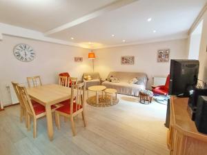 ein Wohnzimmer mit Tisch und Couch in der Unterkunft Le Saint M, T3, wifi, parking, jardin, Saint Mamet in Saint-Mamet