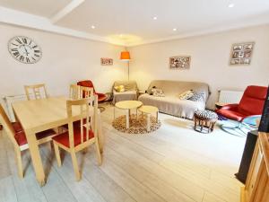 ein Wohnzimmer mit Sofa und Tisch in der Unterkunft Le Saint M, T3, wifi, parking, jardin, Saint Mamet in Saint-Mamet