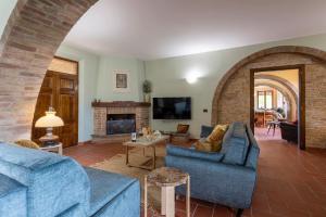 Stazione di ChiancianoにあるPODERE GELLINO 14, Emma Villasのリビングルーム(青いソファ2台、暖炉付)