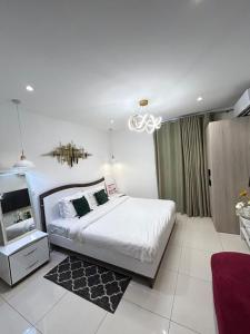a bedroom with a large white bed and a chandelier at Accra finest Luxury Apartments in Accra