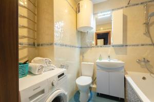 a bathroom with a toilet sink and a washing machine at Lebedinny Flat in Kyiv +4 photos