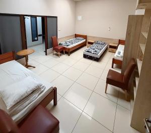 a hospital room with two beds and a chair at ZM Książ in Książ Wielkopolski