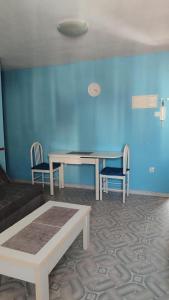 ein Raum mit einem Tisch und Stühlen und einer blauen Wand in der Unterkunft Apartamento en playa de Gandía in Playa de Gandia + 1 Foto