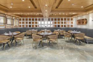a restaurant with tables and chairs in a room at The Ashirwad Kufri Resort By Pandora Hotels & Resorts in Kūfrī