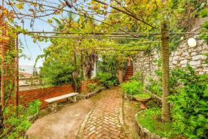 un giardino con una panchina e un sentiero in mattoni di Corte del Poeta, TerreMarine a Vezzano Ligure