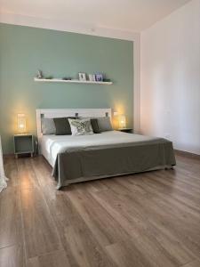 a bedroom with a large bed and wooden floors at B&B Il giardino segreto in Guarda Ferrarese