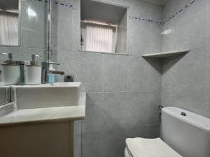 a white bathroom with a sink and a toilet at Acogedor Apartamento en Cudillero in Cudillero +17 photos
