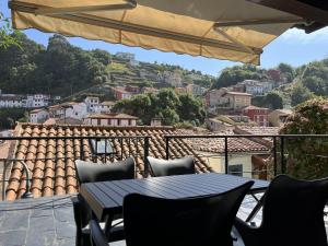 a table and chairs on a balcony with a view at Acogedor Apartamento en Cudillero in Cudillero