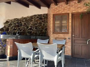 a table and chairs in front of a brick wall at Acogedor Apartamento en Cudillero in Cudillero