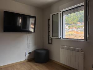 a living room with a flat screen tv and a window at Acogedor Apartamento en Cudillero in Cudillero