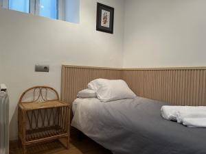 a bedroom with two beds and a chair and a window at Acogedor Apartamento en Cudillero in Cudillero