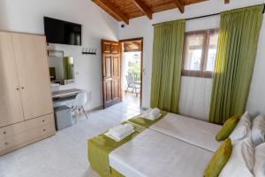 une chambre avec un grand lit et une télévision dans l'établissement Blue Waves Corfu, à Kavos 88 autres photos