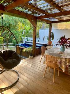 Un patio con una mesa y una piscina. en Maison Zen avec jacuzzi privatif, en Étang-Salé