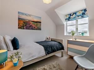 a bedroom with a bed and a desk and a window at 2 Bed in Helmsley G0037 in Helmsley