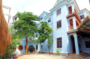 a blue building with a tree in front of it at Angkor Gecko's Inn Hotel & Guesthouse in Siem Reap