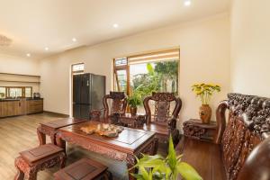 a living room with a table and chairs and a refrigerator at TT House Pleiku in Plei Kêp