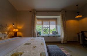 a bedroom with a large bed and a window at Tehla Bagh in Tehla