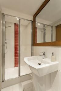 une salle de bain blanche avec un lavabo et une douche dans l'établissement Biolay 1, à Chamonix-Mont-Blanc