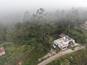 an aerial view of a house in the middle of a forest at Cold Stone Villa -a cozy escape above the clouds in Kodaikānāl