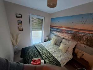 een slaapkamer met een bed met een schilderij aan de muur bij apartament MT2 bursztynowe osiedle in Jantar