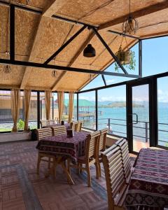 a dining room with a table and chairs and the ocean at Sea Star in Sevan