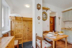 une cuisine avec une table en bois et une table et des chaises dans l'établissement Hermitage Studio - close to ski pistes - Happy Rentals, à Borgata Sestriere